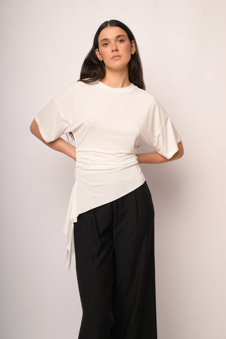 Maglia color panna drappeggiata con fondo asimmetrico