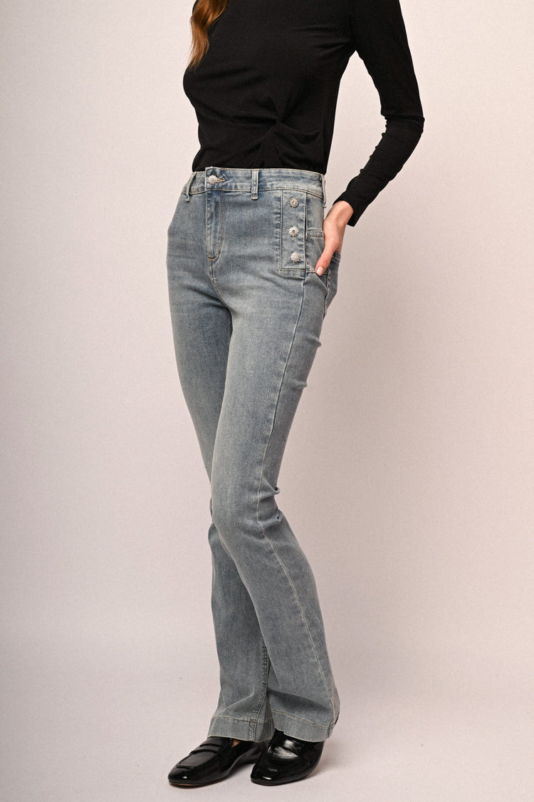 Jeans a gamba svasata in denim azzurro con bottoni gioiello