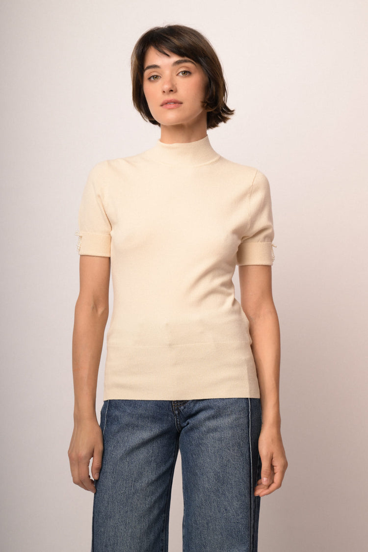 Lupetto in maglia beige con fiocchetti decorativi alle mezze maniche