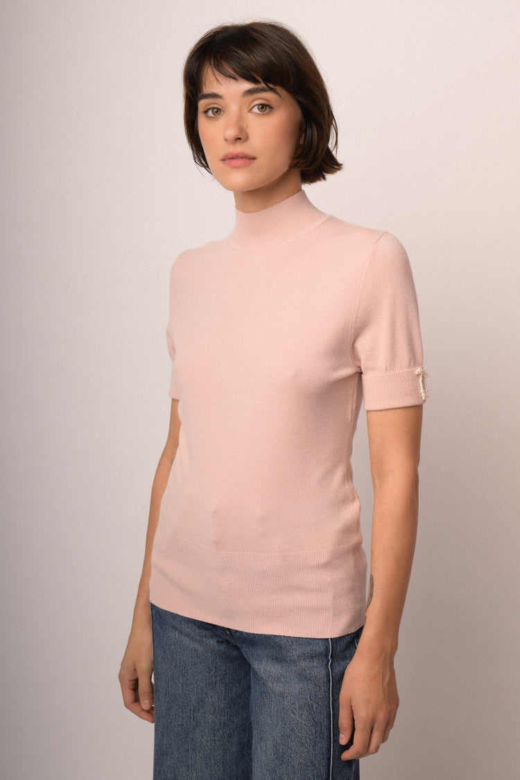 Lupetto in maglia rosa con fiocchetti decorativi alle mezze maniche
