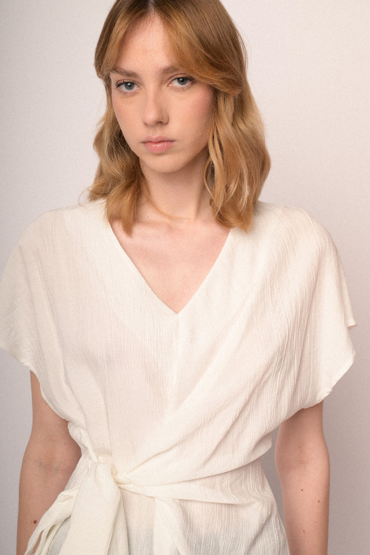 Top beige con scollo a V e fiocco da annodare